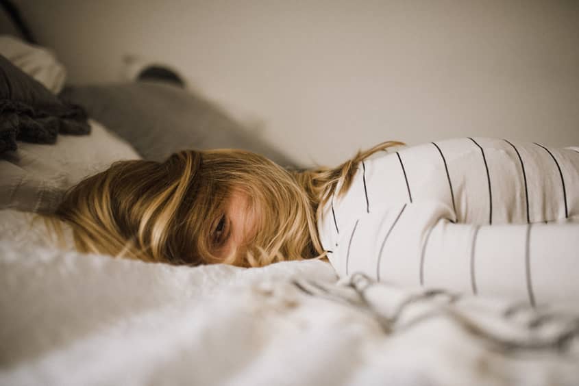 A woman lying in bed, unable to fall asleep